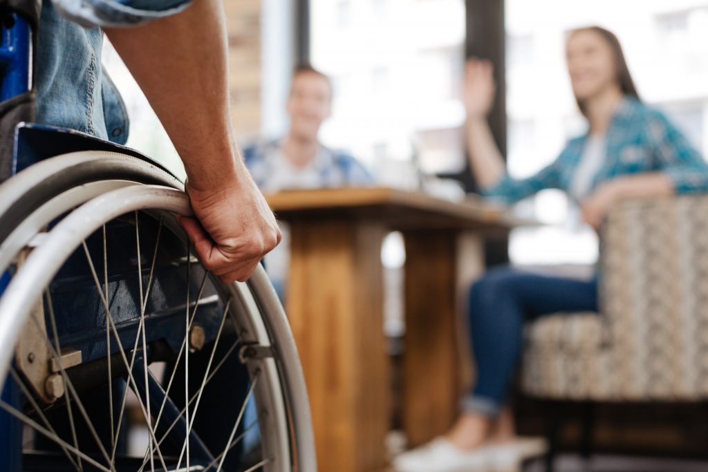 Confident handicapped man meeting his friends Cet homme est en situation d'handicap, il rejoint ses amis